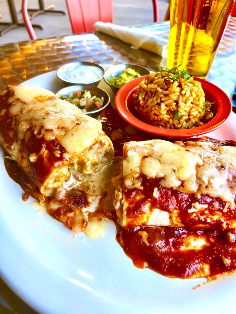 Delicious chicken burrito with hot sauce and melted cheese, a flavorful Mexican cuisine specialty at Las Cruces Tex Mex in Metairie.