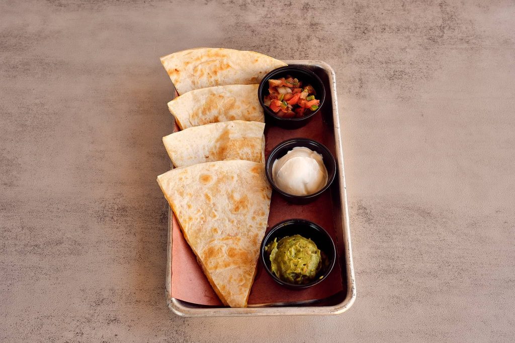 Delicious quesadillas served with dips at a Mexican restaurant in Metairie, ideal for a flavorful dinner at Las Cruces.