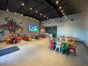 Indoor event space at Las Cruces, featuring colorful chairs around tables - Mexican restaurant in Metairie